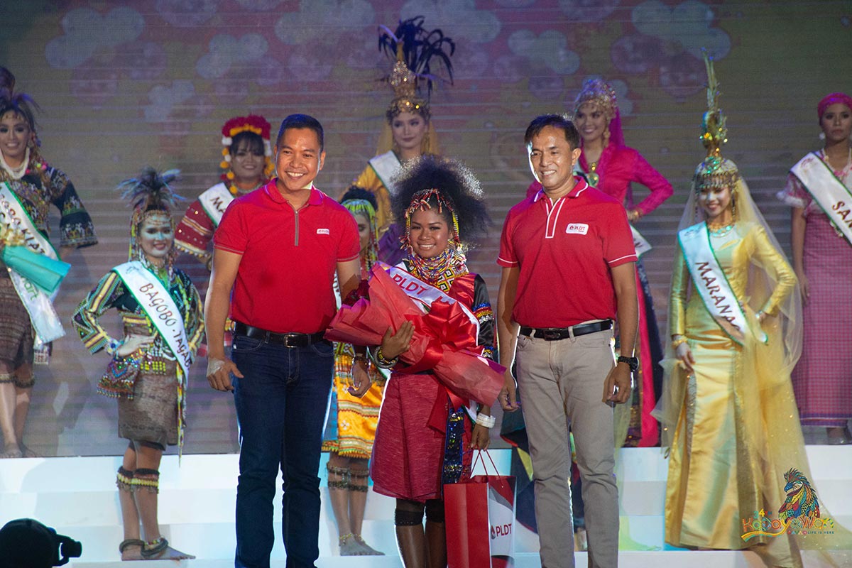 PLDT Mindanao Area Consumer Experience Head Alan Abrina (left) and PLDT Customer Development Management Executive Jun Palar (right) confer the Hiyas ng PLDT special award to Aileen Maray from the Ata Tribe