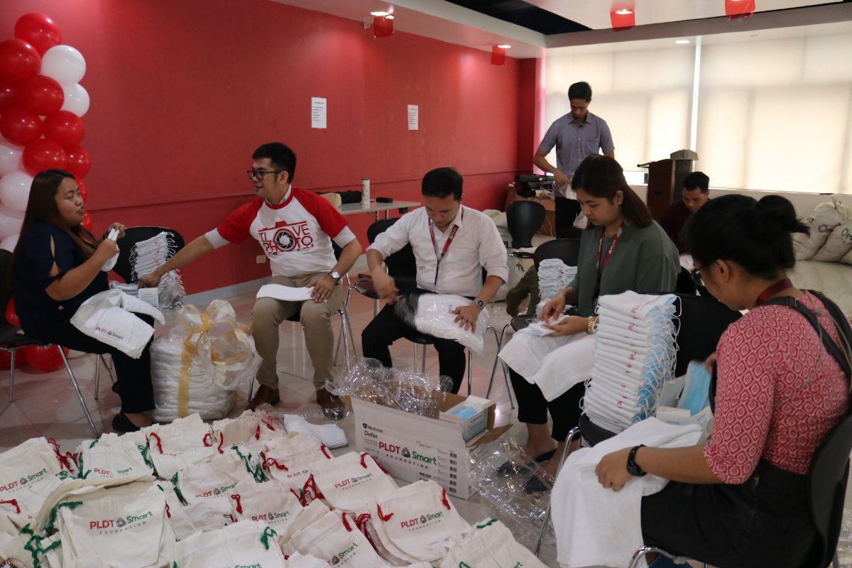 Employee-volunteers help repack hygiene kits for the displaced families affected by the Taal Volcano eruption.