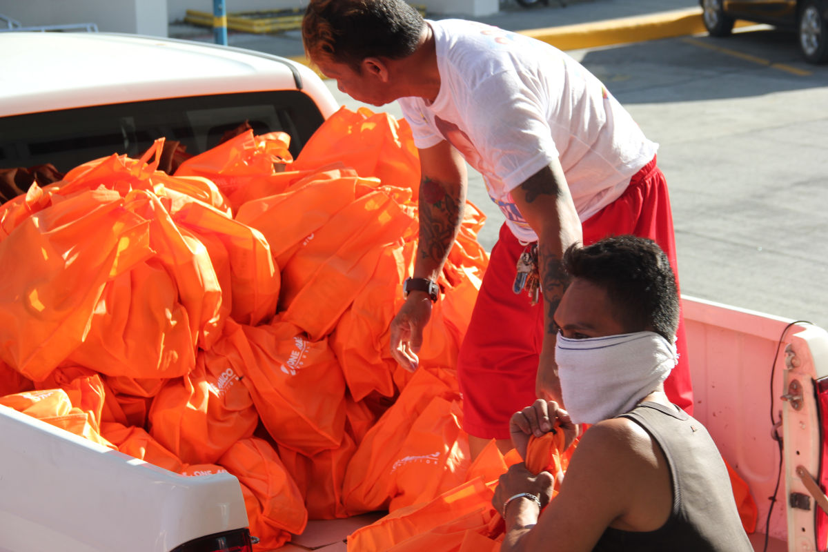 Community volunteers help distribute 300 relief packs from One Meralco Foundation.