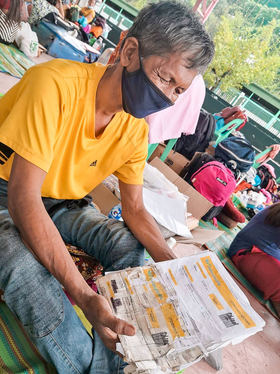 54-year-old Dennis Sebastian shows his flight ticket back to his hometown in Compra, Liloy in Zamboanga del Norte. 