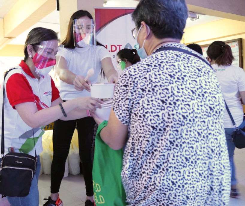 PLDT-Smart Foundation President Esther Santos and Your 200 Pesos Co-founder Michele Gumabao prepare the meals for distribution.