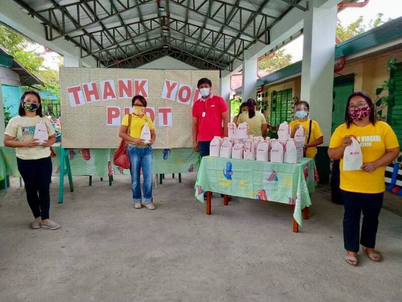 Teachers in Pili West Central School receive their hygiene kits from PLDT Bicol CX Zone Workforce Management Supervisor Anthony Paranal.