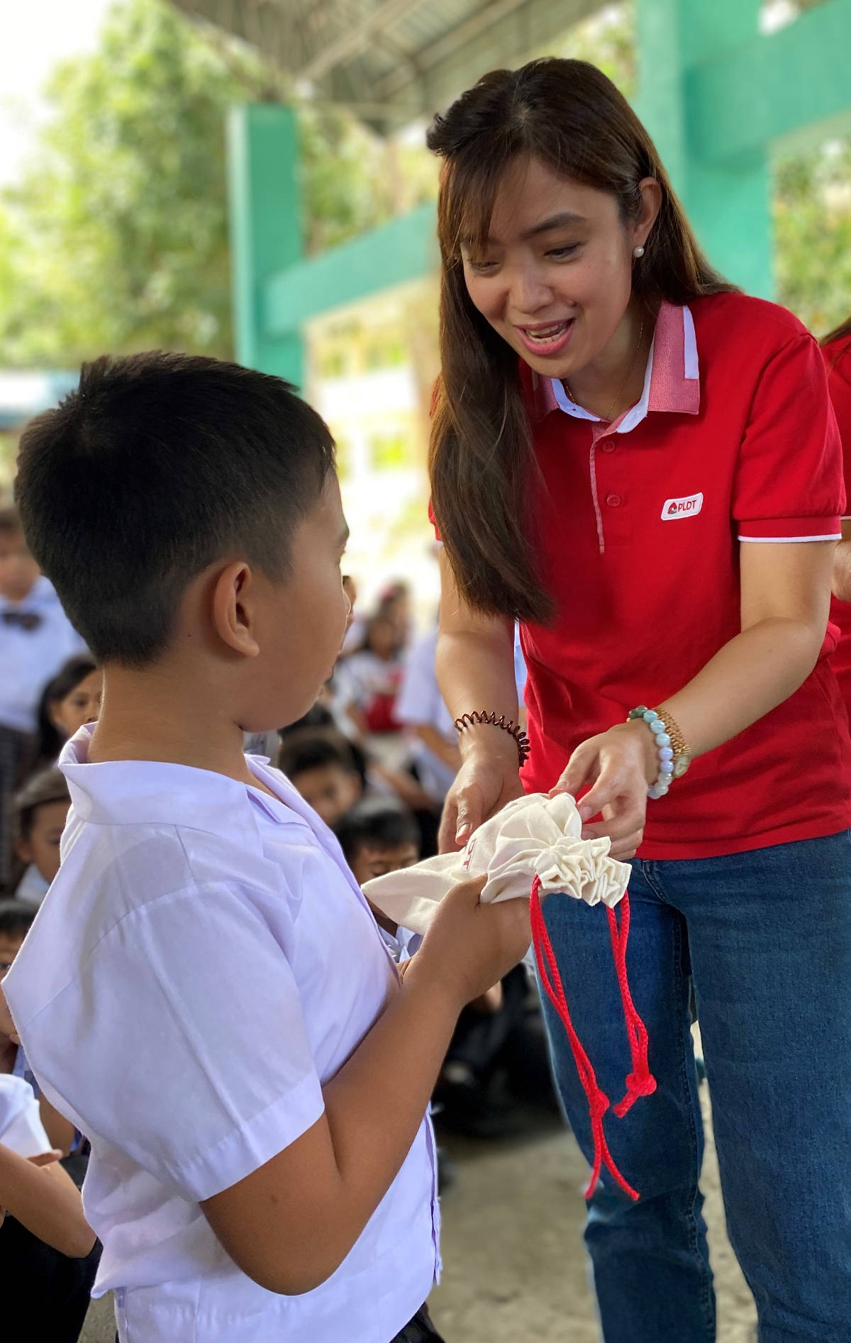 PLDT Community Relations Division Head Katherine P. Diaz De Rivera gives a hygiene kit to a student.