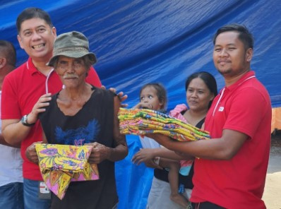 PLDT GenSan-Cotabato Consumer Experience Zone Head Melvin Lacuna, left, leads the distribution of malongs to the beneficiaries. 