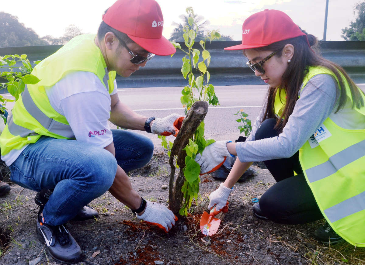 Metro Pacific Tollways Corporation Chief Financial Officer Christopher C. Lizo and PLDT Community Relations Division Head Katherine P. Diaz De Rivera plant a seedling during the environmental initiative.