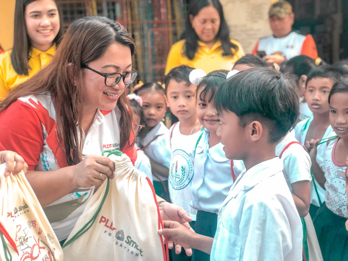 A student from Guihay Elementary School in Lopez Quezon receives a Sack of Joy from PLDT-Smart Foundation.